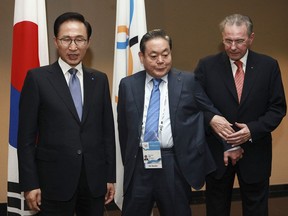 FILE - In this July 5, 2011, file photo, President of the International Olympic Committee (IOC) Jacques Rogge, right, meets with South Korean President Lee Myung-bak, left, and Samsung Chairman Lee Kun-hee, center, in Durban, South Africa, ahead the opening ceremony for the 123rd IOC session that will decide the host city for the 2018 Olympics Winter Games. Samsung has denied a media report it launched illicit lobbying to help bring the 2018 Winter Olympics to Pyeongchang, South Korea.