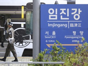 A South Korean army solider passes by a signboard showing the distance to North Korea's capital Pyongyang and to South Korea's capital Seoul from Imjingang Station in Paju, South Korea, near the border with North Korea, Friday, April 20, 2018. North and South Korea have installed a telephone hotline between their leaders as they prepare for a rare summit next week aimed at resolving the nuclear standoff with Pyongyang.