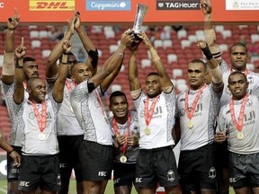 Rugby sevens team from Fiji celebrate with their medals and winner's trophy after winning the HSBC World Rugby Sevens Series 2018 finals on Sunday, April 29, 2018, in Singapore.