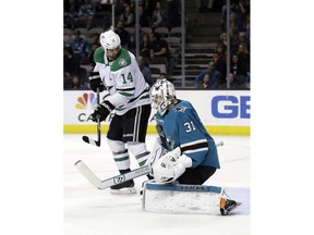 San Jose Sharks goaltender Martin Jones (31) stops a shot next to Dallas Stars' Jamie Benn during the first period of an NHL hockey game Tuesday, April 3, 2018, in San Jose, Calif.