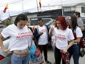 Supporters of presidential candidate Carlos Alvarado of the ruling Citizen Action Party don T-shirts promoting their candidate outside party headquarters in San Jose, Costa Rica, Saturday, March 31, 2018. Voters will choose Sunday between Alvarado and Fabricio Alvarado of National Restoration. A recent poll indicated a statistical tie in the second-round runoff vote.