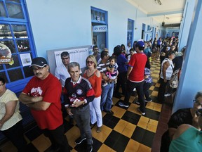 Voters stand in line at a polling station during a presidential election in San Jose, Costa Rica, Sunday, April 1, 2018. Voters will choose between Carlos Alvarado of the ruling Citizen Action Party and Fabricio Alvarado of National Restoration Party.