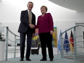 Filippo Grandi, left, UN High Commissioner for Refugees, and German Chancellor Angela Merkel, right, shake hands after a statement prior to a meeting in Berlin, Germany, Monday, April 23, 2018.