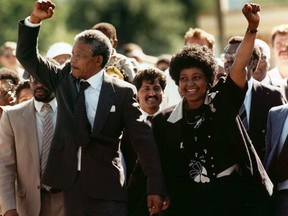 In this file photo dated Sunday, February 11, 1990, Nelson Mandela and wife Winnie walk hand in hand, raising their clenched fists upon his release from Victor prison, Cape Town, after 27 years in detention.