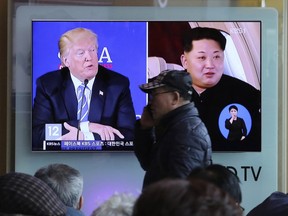 A man passes by a TV screen showing file footage of U.S. President Donald Trump, left, and North Korean leader Kim Jong Un during a news program at the Seoul Railway Station in Seoul, South Korea, Monday, April 9, 2018.