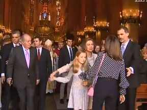 King Juan Carlos I, at left, looks on as Queen Letizia (back to camera) appears to tussle with former Queen Sofia, who was trying to pose for a photo with Princess Leonor (in white dress, left) and Princess Sofia (obscured) as King Felipe VI of Spain intervenes.