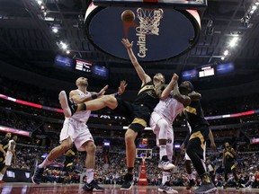 Toronto Raptors center Jakob Poeltl (42) shoots between Washington Wizards center Marcin Gortat, left, and guard Ty Lawson (4) with Raptors forward Pascal Siakam at right during the second half of Game 6 of an NBA basketball first-round playoff series Friday, April 27, 2018, in Washington. The Raptors won 102-92.