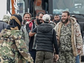 Syrian rebel fighters evacuated from the town of Dumayr, east of the capital Damascus, greet friends upon arriving in the city of Azaz in the northern countryside of Aleppo on April 20, 2018. Dumayr, a town lying further from Eastern Ghouta where a reconciliation agreement had kept a security status quo since 2016, was retaken by government forces the day before.