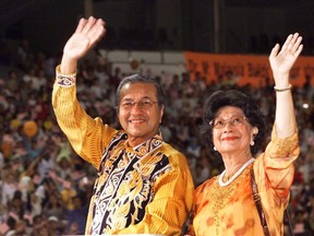 FILE - In this July 27, 2002, file photo, Malaysian Prime Minister Mahathir Mohamad and his wife Siti Hasmah Mohamad Ali, right, wave to supporters during his 21st year in power anniversary celebration at the National Stadium in Kuala Lumpur, Malaysia. The wife of former Malaysian leader Mahathir Mohamad spoke at a press conference on Friday, April 20, 2018 and she is urging women to support the opposition coalition in next month's general election for a better future.