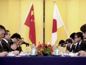 Japanese Foreign Minister Taro Kono, second from right, and his Chinese counterpart Wang Yi, second from left, attend their meeting in Tokyo Sunday, April 15, 2018. Chinese Foreign Minister Wang starts two-day visit with a meeting with  Japanese counterpart Kono. Wang is in Tokyo for the Japan-China Economic dialogue which has been stalled since 2010.