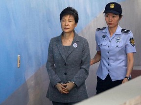 FILE - In this Aug. 25, 2017, file photo, former South Korean President Park Geun-hye, left, arrives for her trial at the Seoul Central District Court in Seoul, South Korea. A South Korean has sentenced disgraced ex-President Park to 24 years in prison over a corruption scandal. The Seoul Central District Court issued the verdict on Friday, April 6, 2018,  after convicting Park of bribery, abuse of power, extortion and other charges. Park has been held at a detention center near Seoul since her arrest in March 2017, but she refused to attend Friday's court session citing sickness.