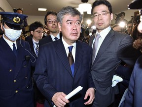 Japan's Vice Finance Minister Junichi Fukuda, center, leaves his ministry in Tokyo Wednesday, April 18, 2018.  The top Japanese finance ministry official has resigned over sexual misconduct allegations.  Fukuda denied the allegations Wednesday but submitted his resignation, citing difficulty carrying out his duties due to escalating criticism and attention.
