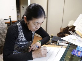 In this March 7, 2018, photo, retired harpist Yumi Makino practices western calligraphy in her apartment room in Tokyo. Makino won a two-year legal battle to get out of a senior citizens home she hated and get her deposit money back in a rare victory over a big real estate company. Her  experience reflects the challenges many older Japanese face in finding suitable care and accommodations in "super-aging" Japan, the world's No. 1 aging nation.