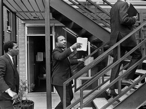 In this April 3, 1968 photo, the Rev. Dr. Martin Luther King Jr., center, and his aides walk at the Lorraine Motel, in Memphis, Tenn., discussing the restraining order King had just received barring them from leading another march in Memphis without court approval. On April 4, at 6:01 p.m., an assassin's bullet found Dr. King on the balcony of the Lorraine just outside his second-floor room, killing him.