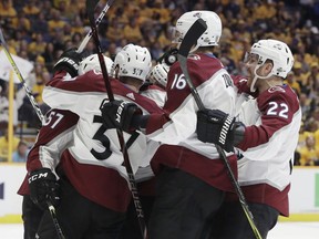 Colorado Avalanche players J.T. Compher (37), Nikita Zadorov (16), of Russia, and Colin Wilson (22) celebrate with Gabriel Bourque (57) after Bourque scored a goal against the Nashville Predators during the first period in Game 2 of an NHL hockey first-round playoff series Saturday, April 14, 2018, in Nashville, Tenn.