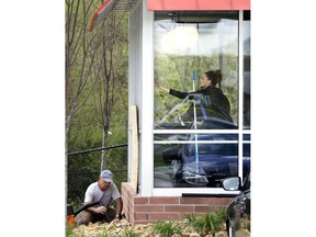 A worker vacuums debris from shattered glass as another worker cleans windows inside a Waffle House restaurant Monday, April 23, 2018, in Nashville, Tenn. A suspect police have identified as Travis Reinking shot and killed at least four people at the Waffle House Sunday.