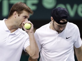 Ryan Harrison, left, of the United States, discusses strategy with teammate Jack Sock before serving during a Davis Cup quarterfinal doubles tennis match against Belgium Saturday, April 7, 2018, in Nashville, Tenn.