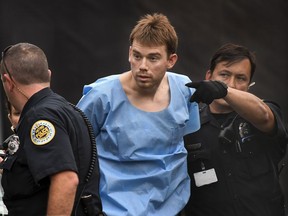 In this Monday, April 23, 2018 photo, Travis Reinking, suspected of killing four people in a late-night shooting at a Waffle House restaurant, is escorted into the Hill Detention Center in Nashville, Tenn., Monday, April 23, 2018.