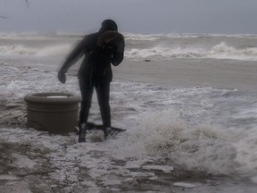 A woman walks along the boardwalk on Toronto's waterfront as a the city is hit by a storm on Sunday, April 15, 2018.