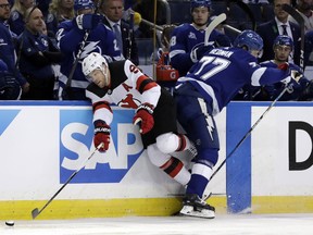New Jersey Devils left wing Taylor Hall (9) is hit by Tampa Bay Lightning defenseman Victor Hedman (77) along the dasher during the first period of Game 1 of an NHL first-round hockey playoff series Thursday, April 12, 2018, in Tampa, Fla.