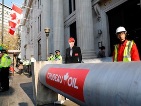 A cardboard cut-out of Prime Minister Justin Trudeau is seen outside the Canadian embassy in London, England, where anti-pipeline protesters blocked the entrance with a fake pipeline on April 18, 2018.