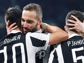 Juventus' Paulo Dybala celebrates with his teammates Gonzalo Higuain and Miralem Pjanic after scoring his team's first goal during the Italian Serie A soccer match between Juventus and Milan at the Allianz Stadium in Turin, Italy, Saturday, March 31, 2018.