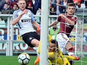 Torino's Adem Ljajic, center,  tries to score as in action with Inter Milan's Milan Skriniar, left, during a Serie A soccer match between Torino and Inter Milan at Turin's Olympic stadium, Italy, Sunday, April 8, 2018.