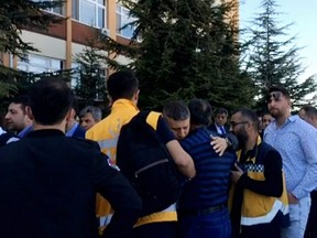 People gather at the entrance of Eskisehir Osmangazi University after a research assistant shot and killed four staff members in Eskisehir, central Turkey, Thursday, April 5, 2018.