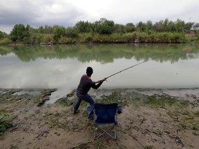 FILE - In this Nov. 12, 2016, file photo, Isac Ramos fishes at a ranch on the banks of the Rio Grande in Los Ebanos, Texas. As hundreds of National Guard troops deploy to the U.S-Mexico border, residents of Texas' southernmost border region are fearful of the impact President Donald Trump's border wall will have. The troops patrolling the Rio Grande will eventually withdraw, but a wall could change the river forever.