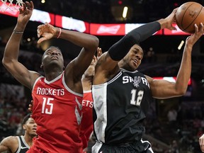 San Antonio Spurs' LaMarcus Aldridge (12) grabs the rebound away from Houston Rockets' Clint Capela during the first half of an NBA basketball game, Sunday, April 1, 2018, in San Antonio.
