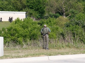 Dallas Police look for a suspect in the shooting of two police officers and a civilian Tuesday, April, 24,2018. Police are near ExtraSpace Storage, south of The Home Depot. Officer in the foreground is behind the Key-Whitman Eye Center on Central Expressway.