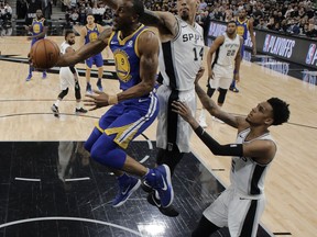 Golden State Warriors forward Andre Iguodala (9) goes up for a shot as San Antonio Spurs' Danny Green (14) and Dejounte Murray (5) defend during the first half of Game 3 of a first-round NBA basketball playoff series in San Antonio, Thursday, April 19, 2018.