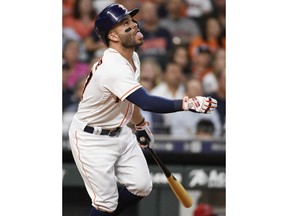 Houston Astros' Jose Altuve watches his shallow fly ball fall for a single during the third inning of a baseball game against the Los Angeles Angels, Monday, April 23, 2018, in Houston.