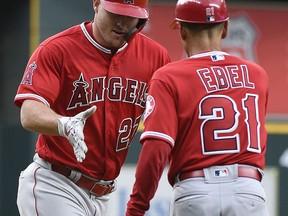 Los Angeles Angels' Mike Trout, left, shakes hands with third base coach Dino Ebel after hitting a solo home run off Houston Astros starting pitcher Charlie Morton during the first inning of a baseball game Tuesday, April 24, 2018, in Houston.