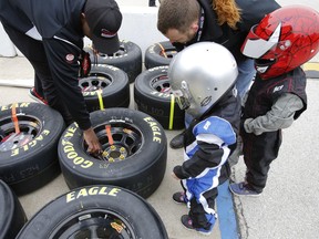 Young NASCAR fans get as lesson in tire prep at Austin Dillon (3) pit before the start of the O'Reilly Auto Parts 500 race at Texas Motor Speedway in Fort Worth, Texas, Sunday, April 8, 2018.