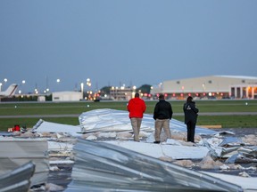 People look over the damage caused by winds at an airplane hangar at William P. Hobby Airport Wednesday, April 4, 2018, in Houston. The National Weather Service says gusts of about 60 mph (100 kph) were recorded late Tuesday at  the airport. Authorities say the wind appears to have caused the hangar at a private terminal to disintegrate. An airport spokesman, Bill Begley, says the collapse caused millions of dollars of damage. There have been no reports of injuries