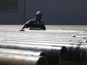 William Hampton walks between steel pipes at the Borusan Mannesmann plant in Baytown, Texas, Monday, April 23, 2018. President Donald Trump's escalating dispute with China over trade and technology is threatening jobs and profits in working-class communities where his "America First" agenda hit home. Borusan said the Baytown production line would no longer be competitive and "jobs would be threatened" if it cannot import 135,000 metric tons of steel annually over the next two years. The pipes Borusan produces are used primarily as casing for oil and natural gas wells.