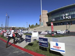 A woman and her baby head to the Maverick Center to attend the Utah Republican 2018 nominating convention Saturday, April 21, 2018, in West Valley City, Utah. Mitt Romney is facing nearly a dozen Republican contenders in Utah on Saturday as he works to secure the state GOP nomination for a Senate seat without a primary.