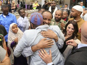 FILE - In this June 18, 2017, file photo, Imam Yussuf Abdi, center back to camera, is welcomed home by friends after arriving at Salt Lake City International Airport. A judge, on Monday, April 23, 2018, has dismissed a lawsuit filed by Abdi, a Utah Muslim leader whose lawyers said he was wrongly placed on a government no-fly list and temporarily blocked from leaving Kenya with his family last year.