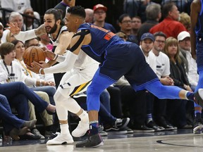 Utah Jazz guard Ricky Rubio, left, and Oklahoma City Thunder guard Russell Westbrook (0) battle for a loose ball in the second half during Game 4 of an NBA basketball first-round playoff series, Monday, April 23, 2018, in Salt Lake City.