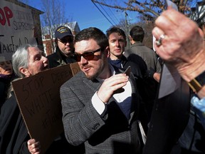FILE - In this Feb. 27, 2018, file photo, Jason Kessler walks through a crowd of protesters in front of the Charlottesville Circuit Courthouse ahead of a decision regarding the covered Confederate statues, during a rally in Charlottesville, Va. The University of Virginia has effectively banned Kessler the main organizer of last summer's white nationalist rally from its Charlottesville campus.