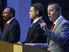 CORRECTS JACKSON'S FIRST NAME TO E.W., NOT L.W. - Republican senatorial candidate, Corey Stewart, left, gestures during a debate between Republican primary senatorial candidates E.W. Jackson, left, Del. Nick Freitas, center, at Liberty University in Lynchburg, Va., Thursday, April 19, 2018.