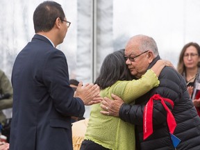 Barney Williams Jr., a residential school survivor, hugs Cindy Tom-Lindley a former student at the Kamloops Indian Residential School near UBC President Santa Ono during the opening of the Indian Residential School History and Dialogue Centre at UBC in Vancouver, B.C., on Monday April 9, 2018.