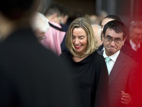 European Union foreign policy chief Federica Mogherini, center, walks with Japan's Foreign Minister Taro Kono, right, after a group photo at a conference 'Supporting the future of Syria and the region' at the Europa building in Brussels on Wednesday, April 25, 2018. EU foreign policy chief Federica Mogherini is calling on Russia, Iran and Turkey to force a halt to fighting in Syria, as international donors gather in Brussels to drum up aid for the conflict-ravaged country.