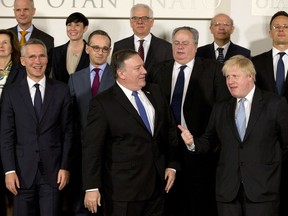 U.S. Secretary of State Mike Pompeo, front center, speaks with British Foreign Secretary Boris Johnson, front right, prior to a group photo of NATO foreign ministers at NATO headquarters in Brussels on Friday, April 27, 2018. NATO is set on Friday to hold its last major meeting in its old headquarters, with talks focused on strained ties with Russia, a fresh peace effort in Afghanistan and a new training mission for Iraq.