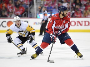 Washington Capitals left wing Alex Ovechkin (8), of Russia, skates with the puck in front of Pittsburgh Penguins defenseman Olli Maatta (3) during the first period in Game 2 of an NHL second-round hockey playoff series, Sunday, April 29, 2018, in Washington.