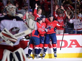 Washington Capitals center Evgeny Kuznetsov, second from right, celebrates his goal with John Carlson (74) and T.J. Oshie (77) during the first period in Game 1 of an NHL first-round hockey playoff series against the Columbus Blue Jackets, Thursday, April 12, 2018, in Washington.