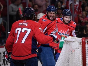 Washington Capitals center Evgeny Kuznetsov, right, celebrates his goal with left wing Alex Ovechkin, center, and right wing T.J. Oshie (77) during the second period of an NHL hockey game against the Nashville Predators, Thursday, April 5, 2018, in Washington.