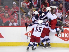 Columbus Blue Jackets left wing Matt Calvert, obscured, celebrates his game-winning goal with Artemi Panarin (9), Mark Letestu (55), Josh Anderson (77), Brandon Dubinsky (17) during overtime in Game 2 of an NHL first-round hockey playoff series against the Washington Capitals, Sunday, April 15, 2018, in Washington. The Blue Jackets won 5-4 in overtime.