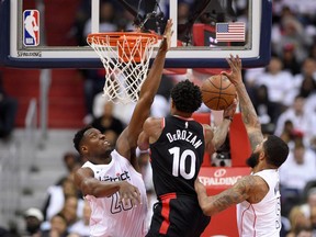 Toronto Raptors guard DeMar DeRozan (10) goes to the basket against Washington Wizards center Ian Mahinmi (28) and forward Markieff Morris (5) during the second half of Game 3 of an NBA basketball first-round playoff series, Friday, April 20, 2018, in Washington.